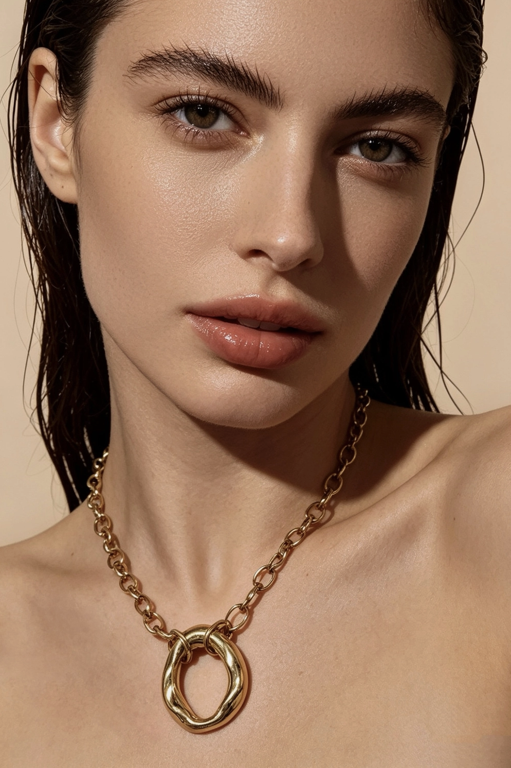 Modelo con collar de oro de eslabones y aro orgánico